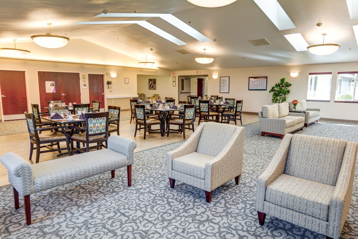 A spacious dining area with neatly arranged tables, chairs, and comfortable seating.
