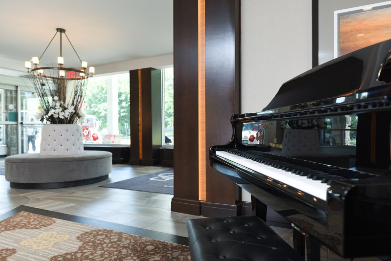 A modern living room with a grand piano and stylish decor.