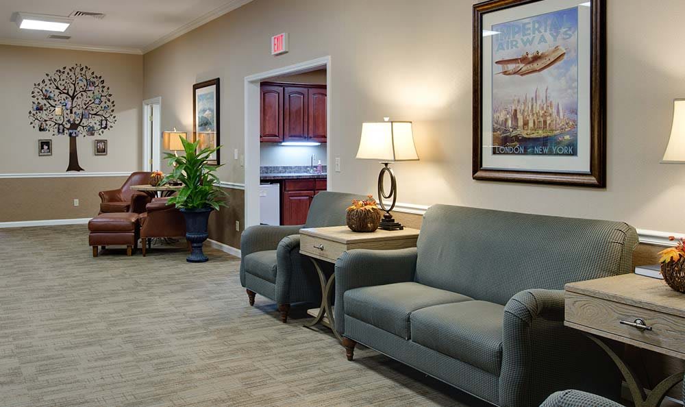 A cozy waiting room with comfortable seating, decorative lamps, and artwork on the walls.