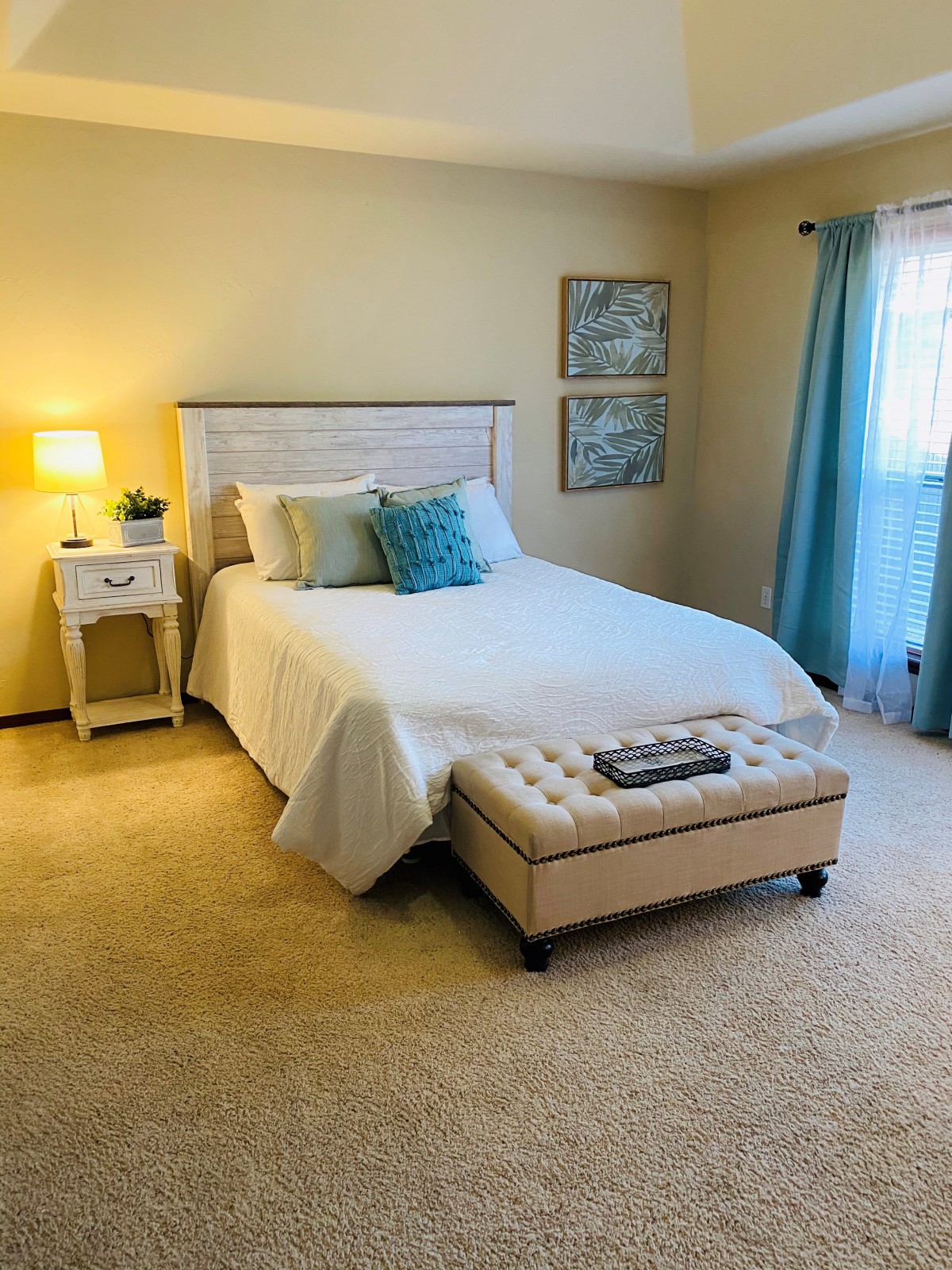 A cozy bedroom with a neatly made bed, soft lighting, and tasteful decor.