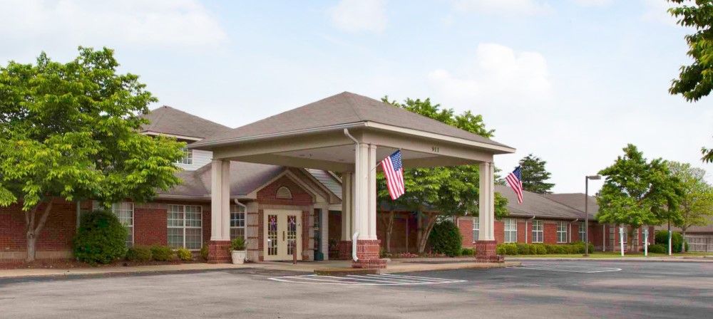 An entrance with a covered patio and American flags displayed.
