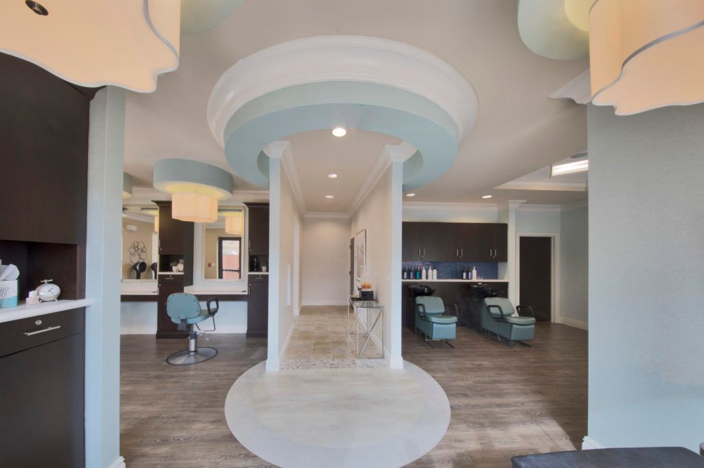 A modern salon interior featuring a stylish waiting area with columns and comfortable seating.