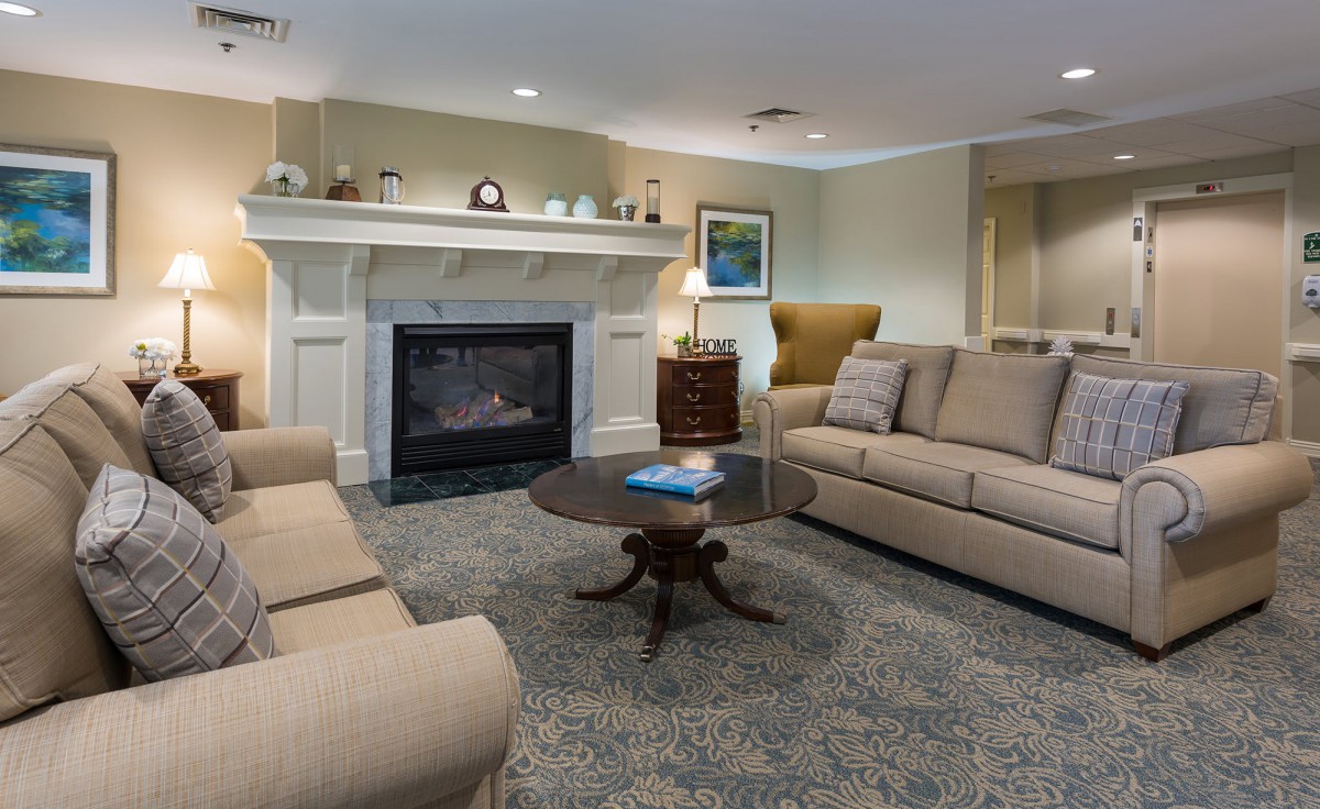 A cozy living room with comfortable seating, featuring a fireplace and elegant decor.