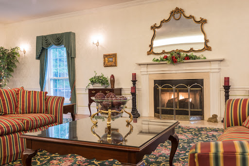 A beautifully decorated living room featuring a warm fireplace and elegant furnishings, creating a cozy and inviting atmosphere.
