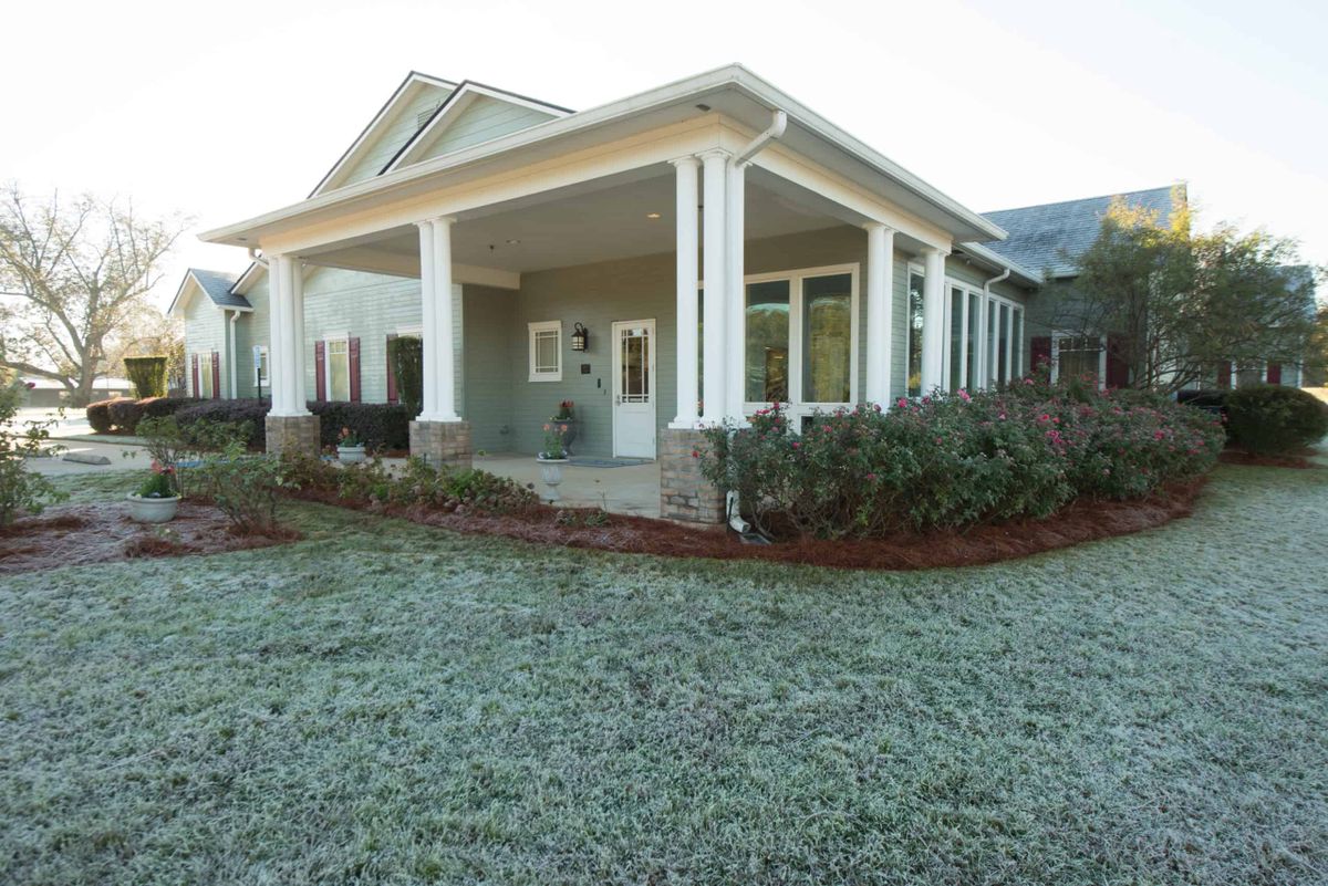 A single-story house with a spacious front porch and well-maintained landscaping.