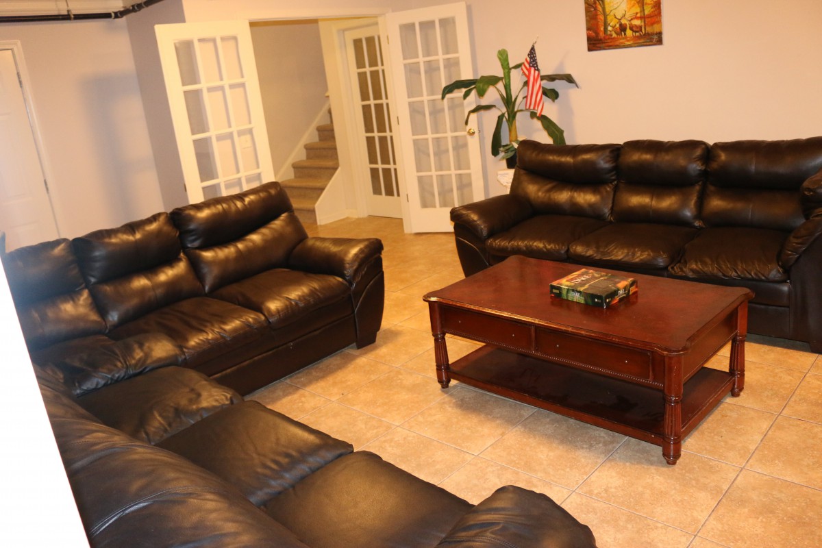 A cozy living room with leather sofas and a wooden coffee table.