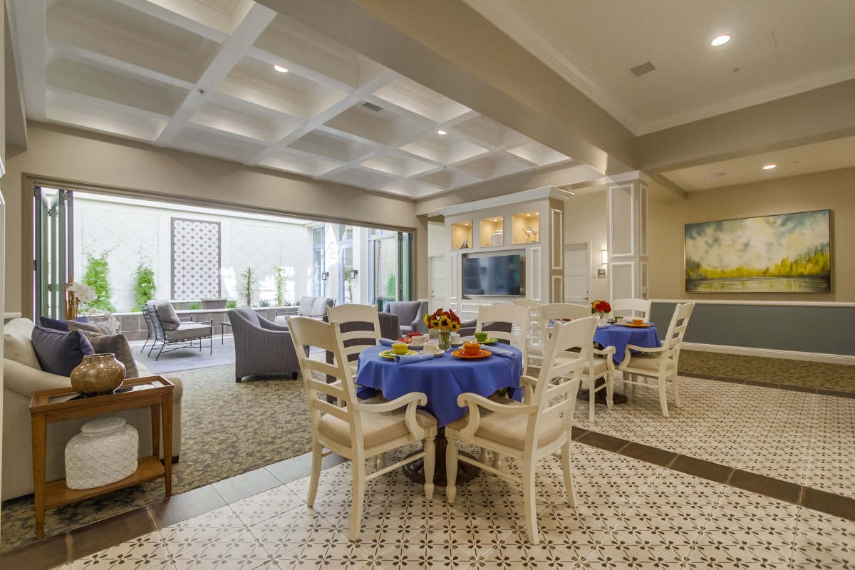 A modern dining and living area with elegant furnishings and blue table settings.