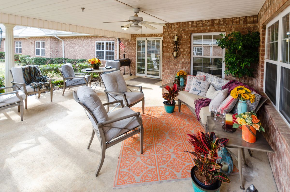 A cozy outdoor patio with comfortable seating, vibrant plants, and decorative touches.