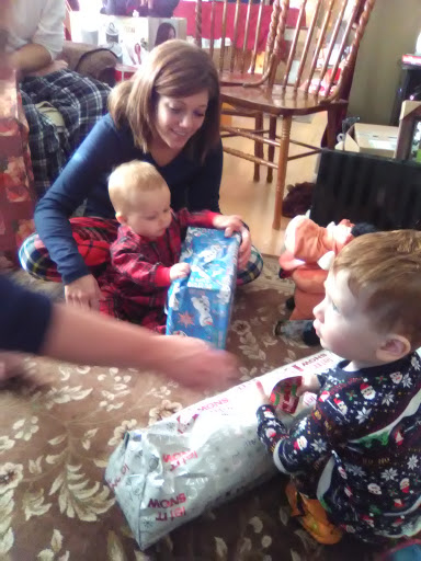 A joyful family moment as children excitedly open gifts during a holiday celebration.