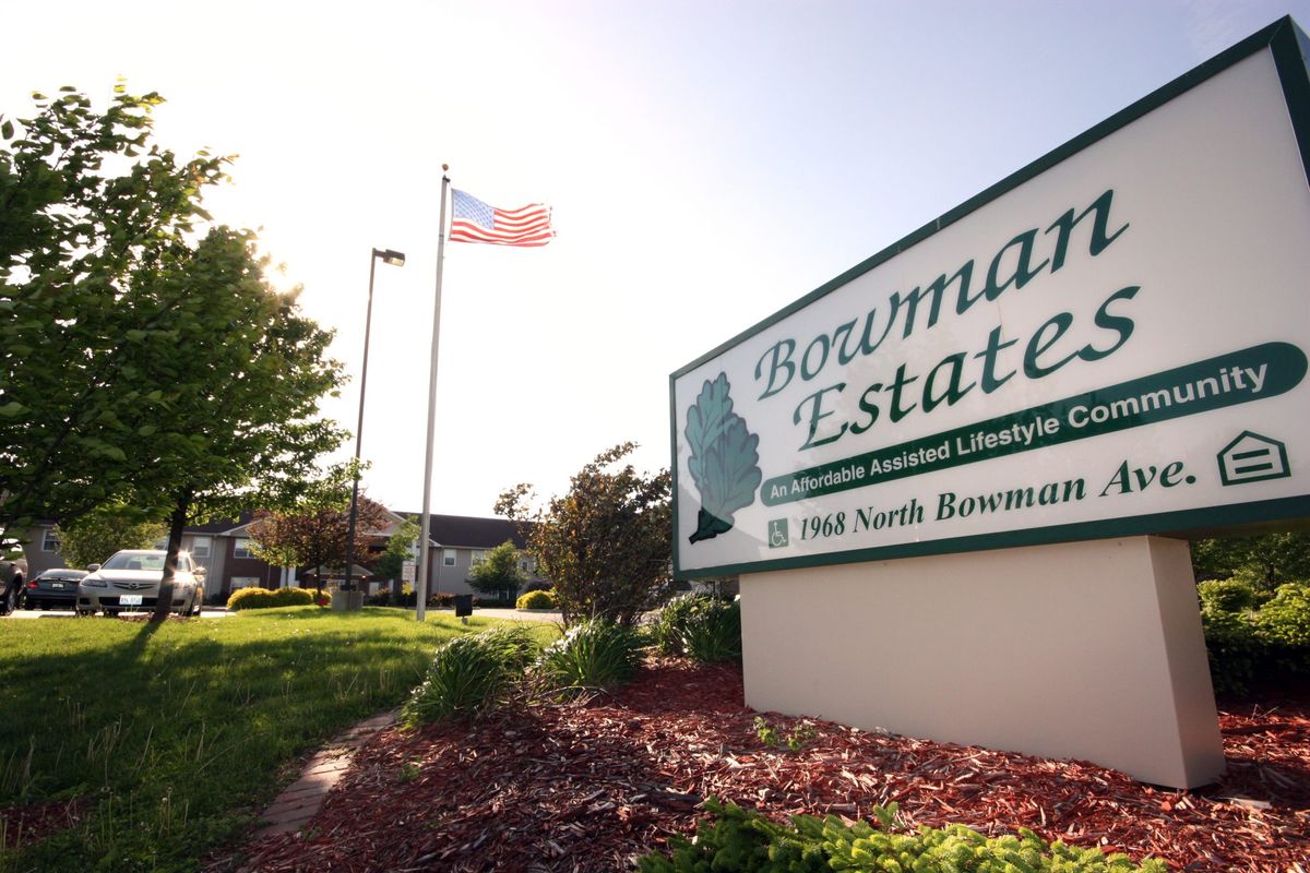 An outdoor view of the Bowman Estates sign with an American flag in the background.