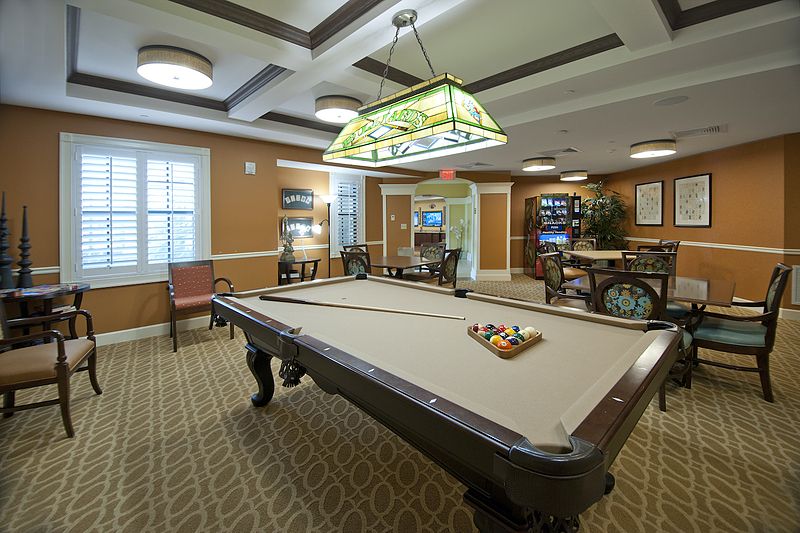 A well-furnished game room featuring a billiards table and classic decor.