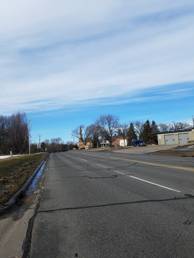 A quiet street scene with trees and buildings under a clear sky.