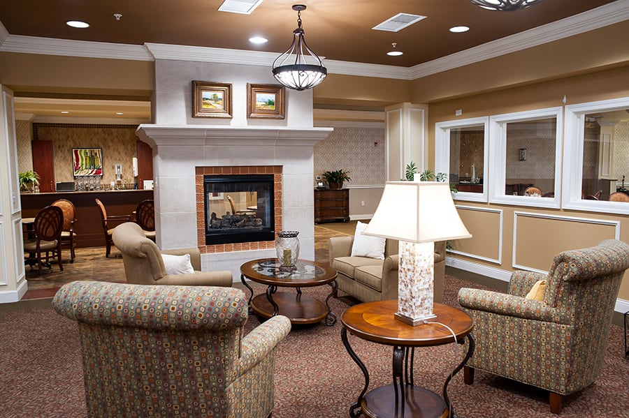 A cozy living room featuring comfortable armchairs, a central fireplace, and elegant decor.