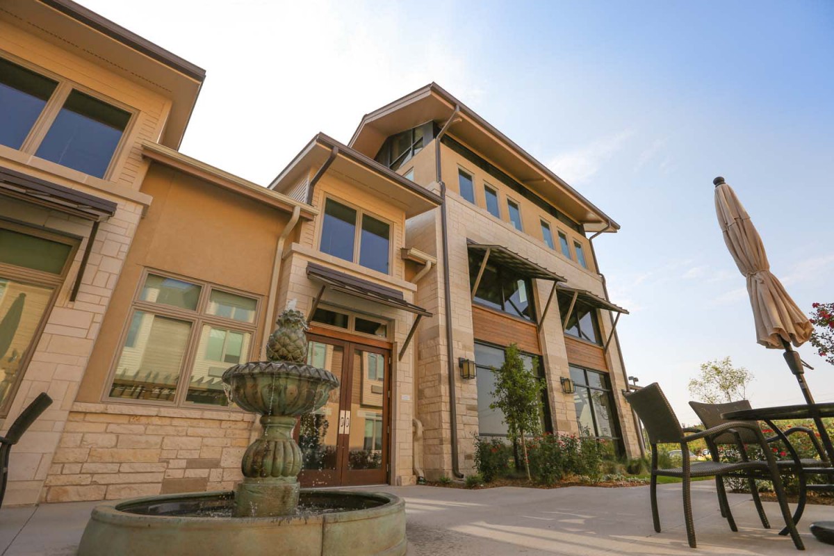 A modern residential house with a stylish exterior and a front yard fountain.