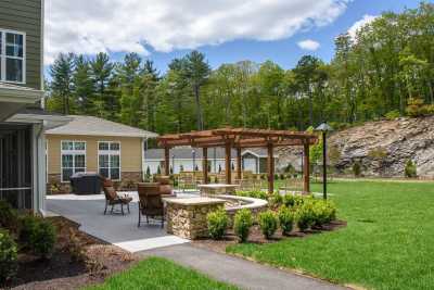 A beautifully landscaped garden with a pergola and seating area, surrounded by lush greenery.