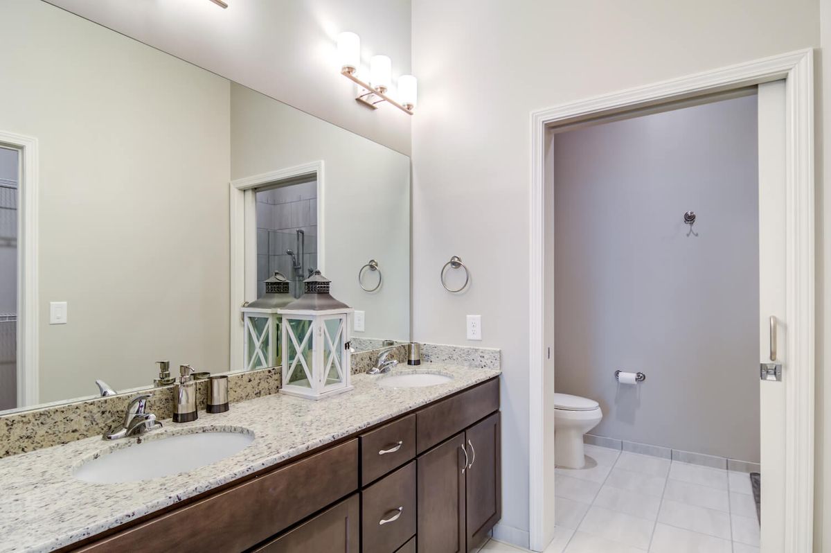 A modern bathroom with a vanity and separate toilet area.