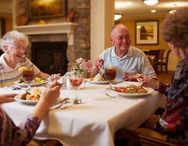 A group of elderly people enjoying a meal together in a cozy dining setting.