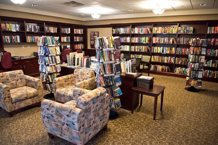 A cozy library reading area with bookshelves and comfortable armchairs.