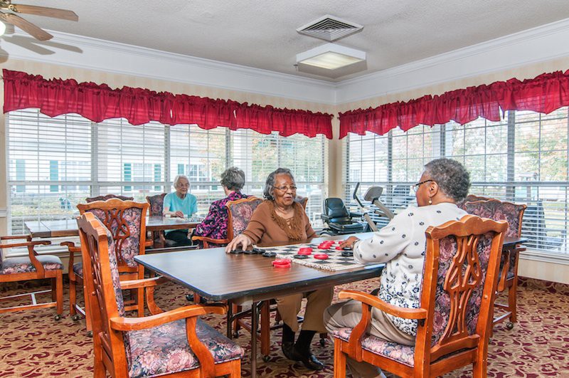 A group of seniors engaged in a board game at a community center.
