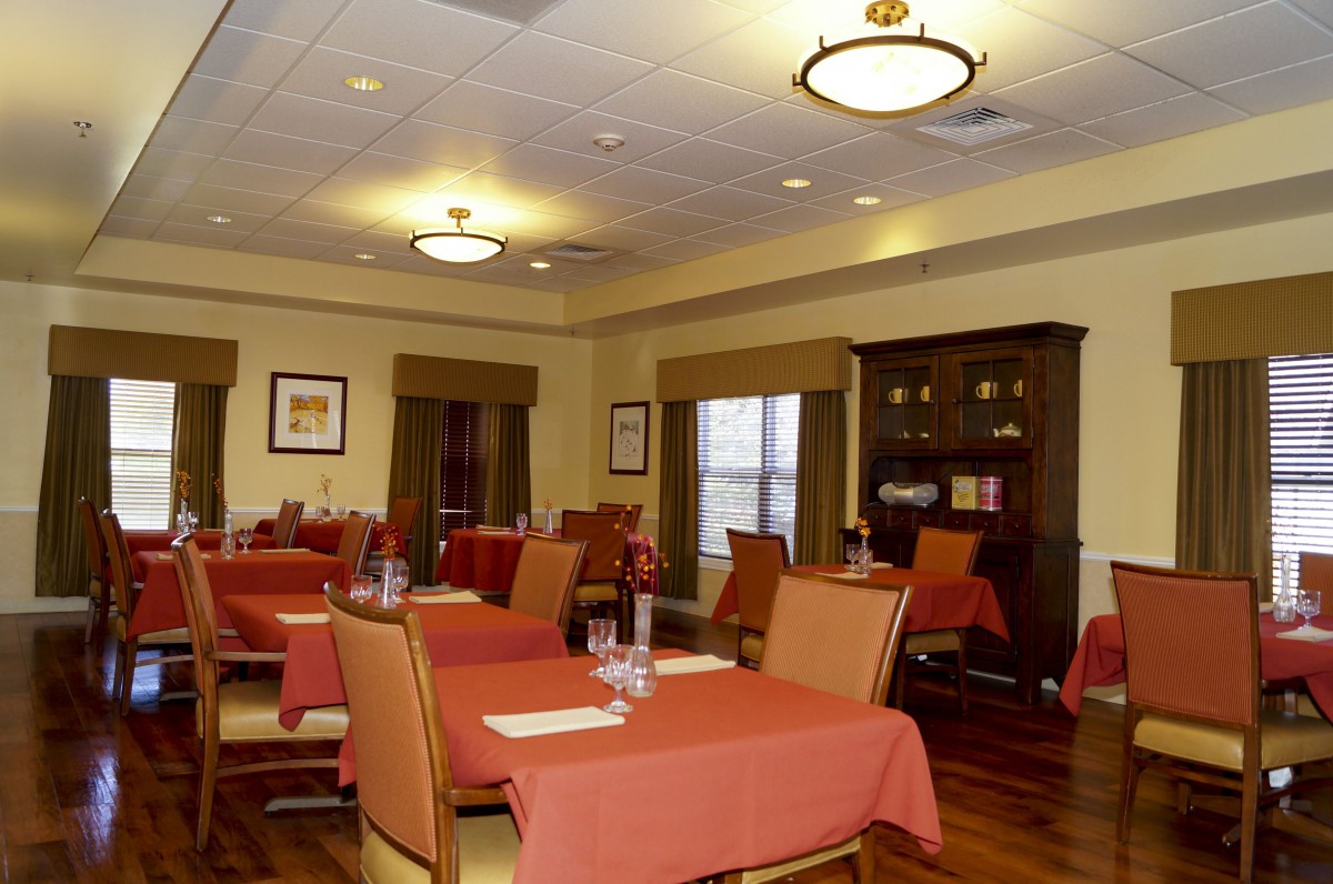 A cozy dining room with tables and chairs, set up for a restaurant.