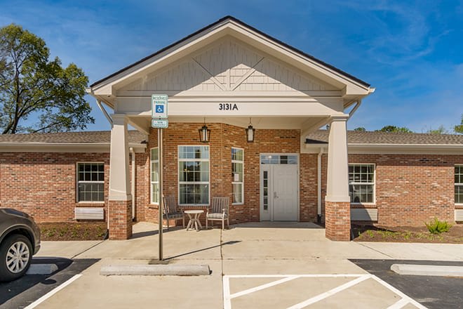 Front view of a brick building with a parking space.