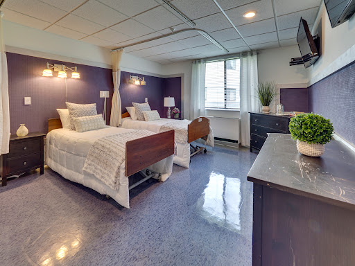 A modern hospital room featuring two neatly arranged beds and bright, welcoming decor.
