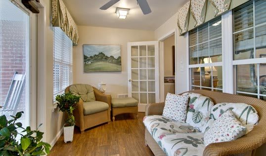 A cozy living room with a mix of comfortable seating, natural lighting, and tasteful decor.