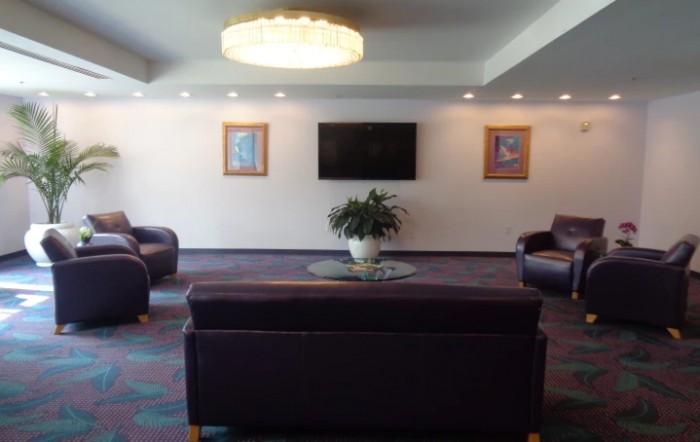 A modern lobby with comfortable seating, a television, and decorative artwork.