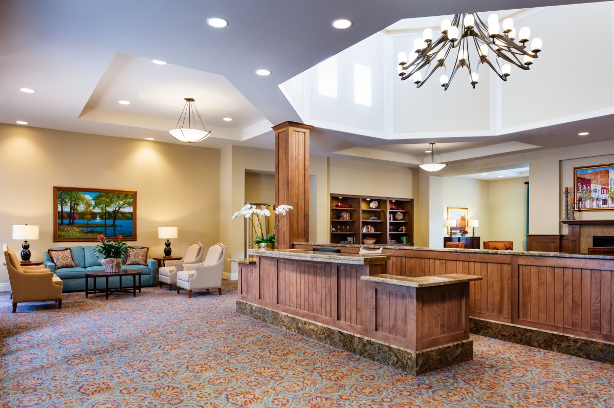 A well-lit lobby with a central reception desk and comfortable seating area.
