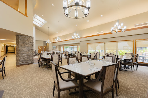 A spacious and elegantly designed dining area featuring modern furnishings and ample natural light.