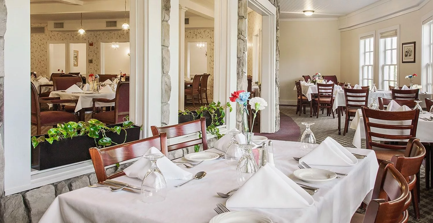 An elegantly set dining area in a restaurant with neatly arranged tables and chairs.