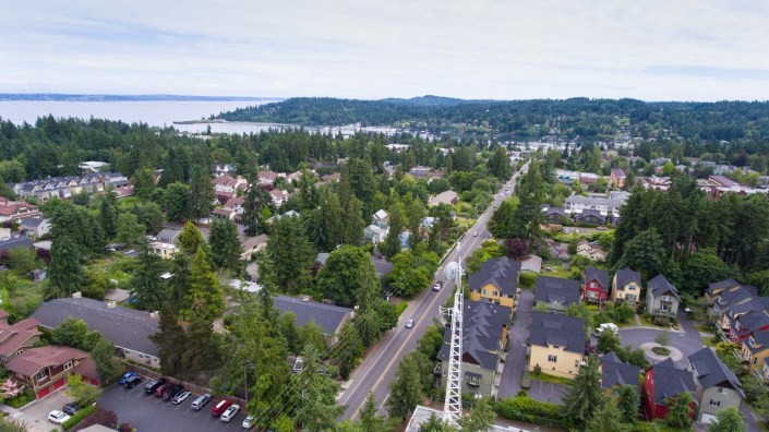 Aerial view of a small town surrounded by lush greenery and roads.
