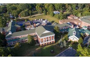 Aerial view of a campus building surrounded by trees.