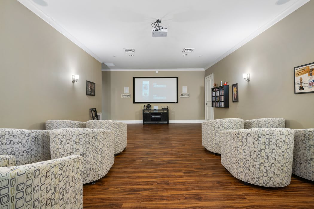 A modern living room with comfortable seating and a projector screen.