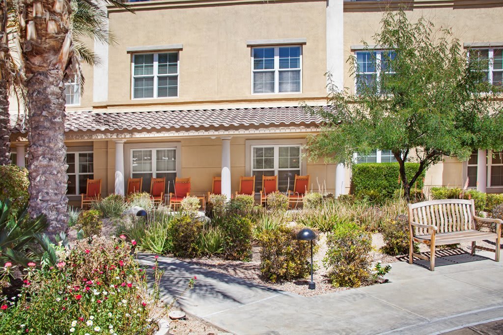 A residential building with a landscaped garden and outdoor seating area.