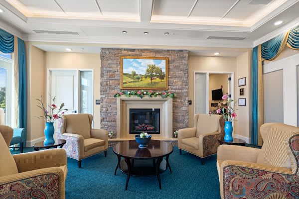 A cozy living room with a fireplace, surrounded by comfortable seating and elegant decor.