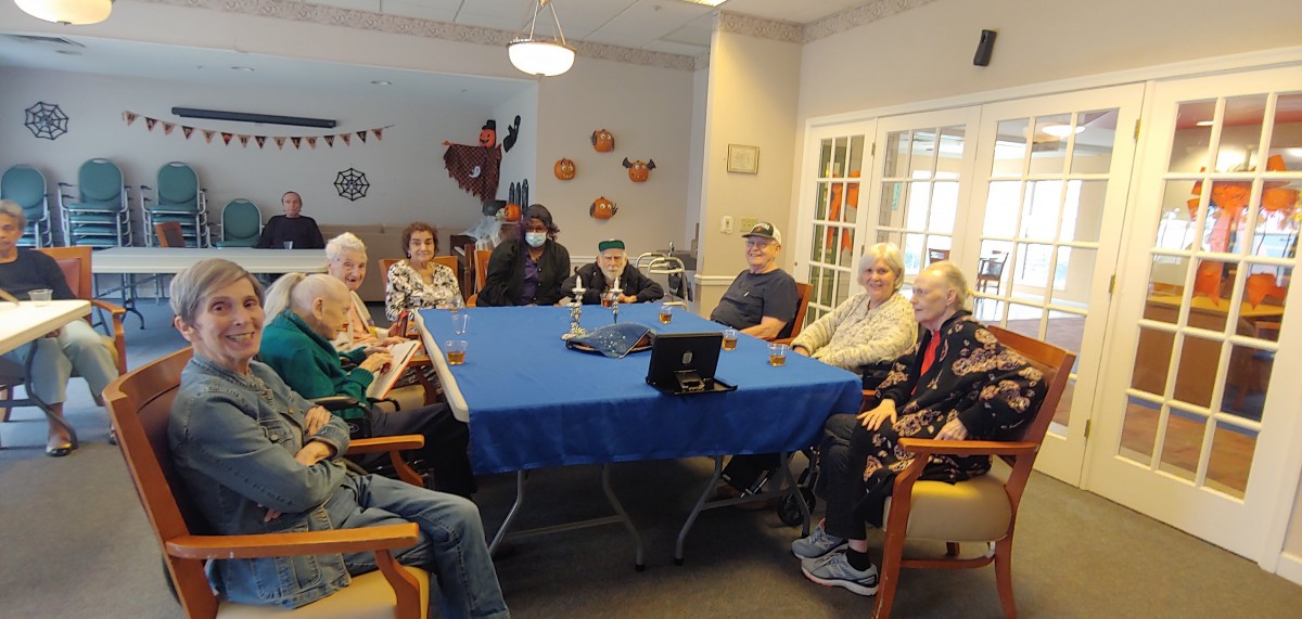 A group of seniors gathered indoors around a table for a social event.