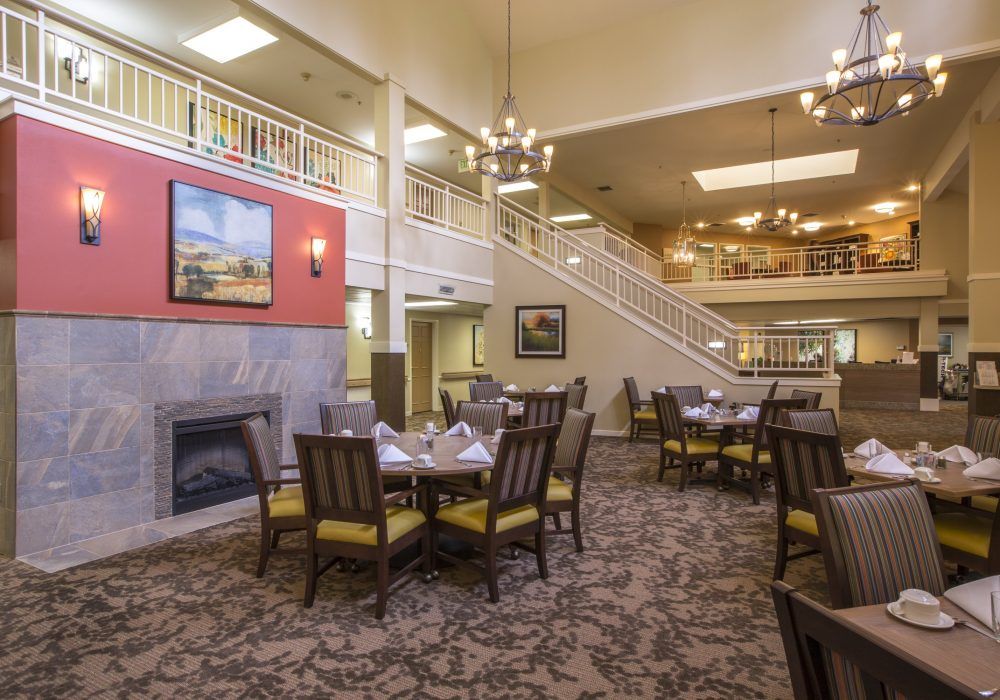 A spacious and elegant dining area with tables, chairs, and chandeliers.