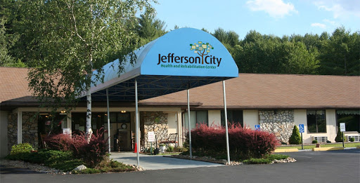Entrance of Jefferson City facility featuring a blue awning and landscaped surroundings.