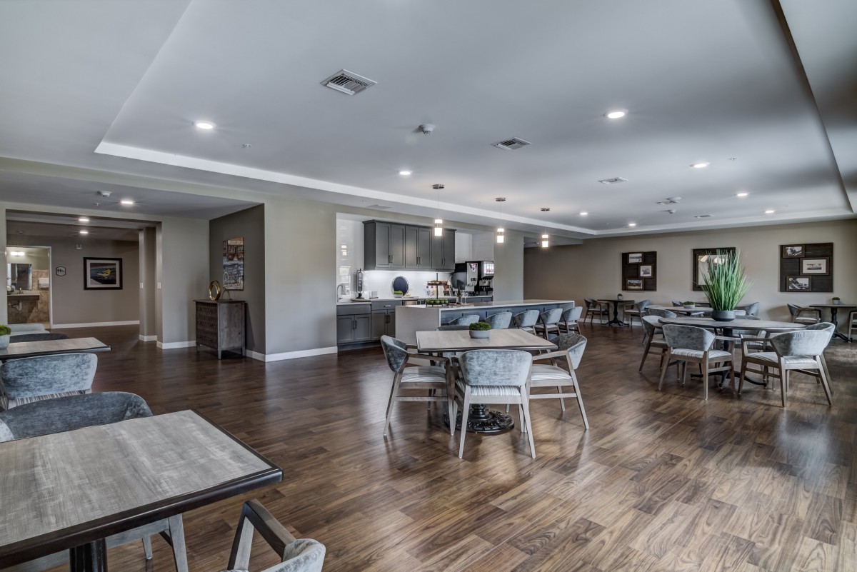 Spacious dining area with modern furnishings and wood flooring.