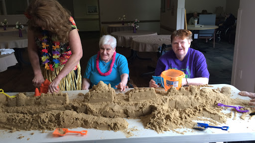 Elderly residents enjoying a fun indoor sand crafting session.