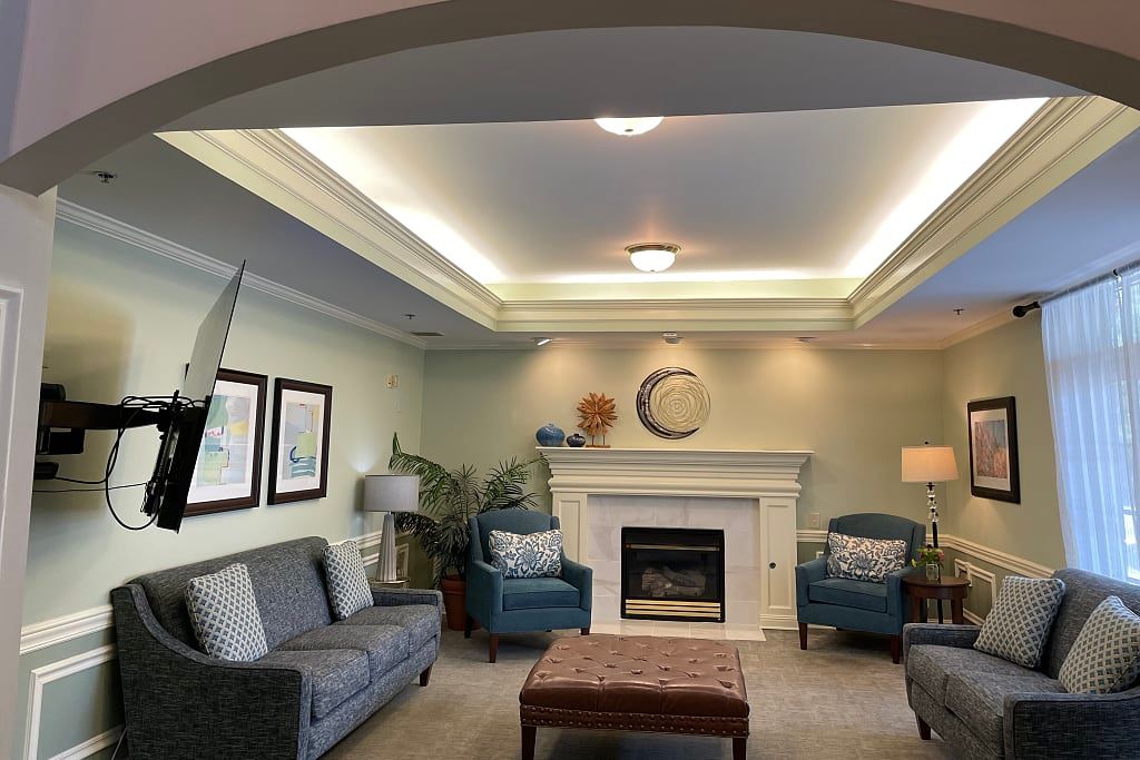 A well-decorated living room featuring a comfortable seating arrangement, a central fireplace, and ambient lighting.