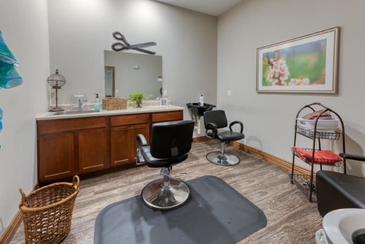 A well-organized hair salon with chairs and a large mirror.