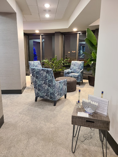 A cozy lobby seating area featuring stylish chairs and greenery.