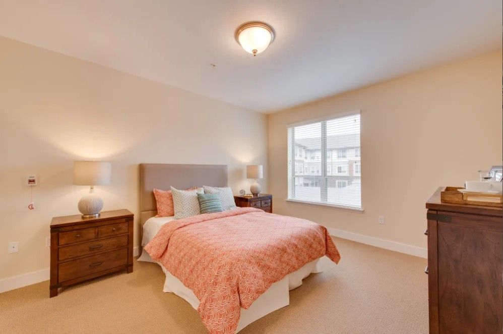 A cozy bedroom with a neatly made bed and warm lighting.