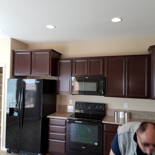 A modern kitchen featuring dark wood cabinetry and sleek appliances.