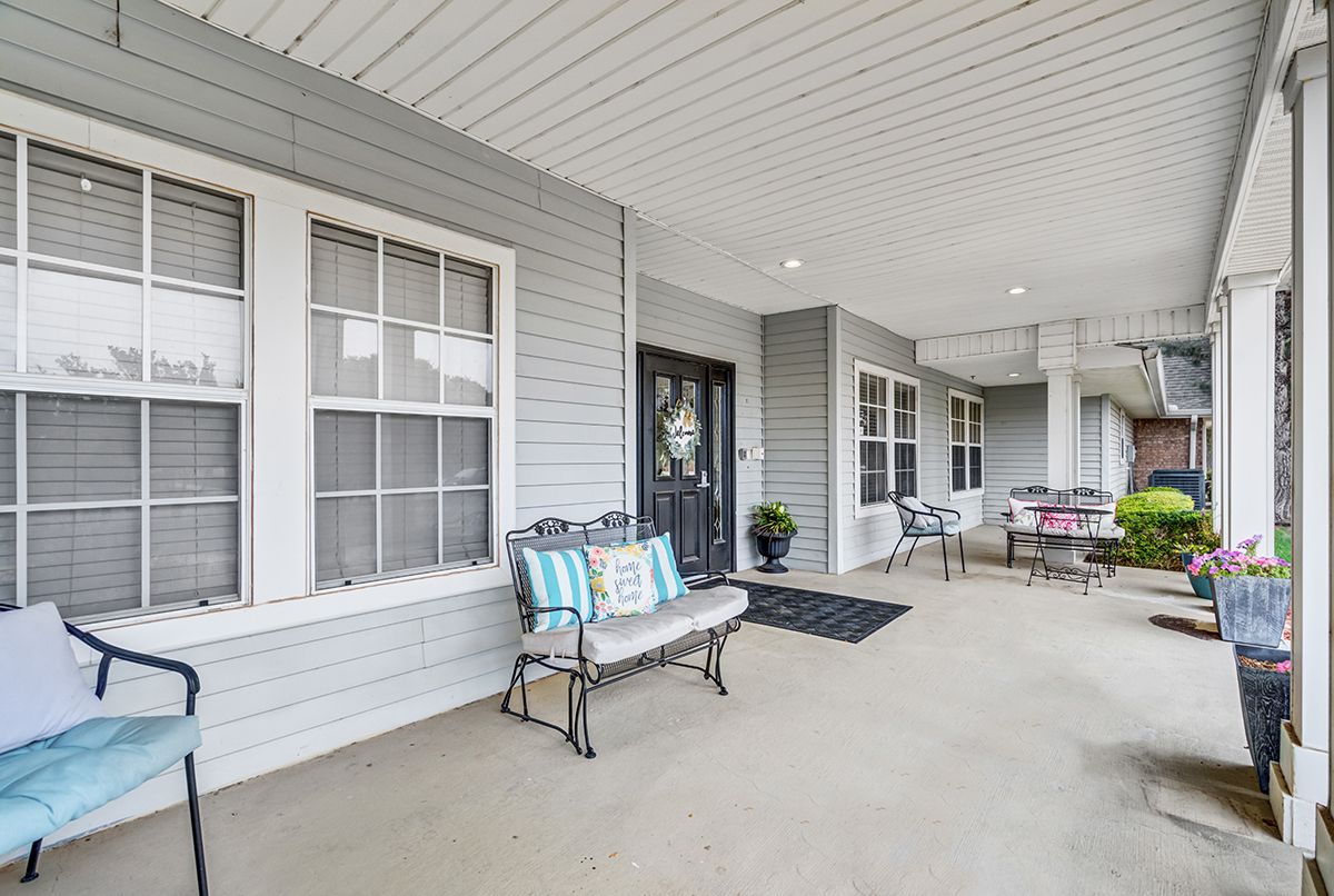 A welcoming porch with seating and decorative elements in front of a house.