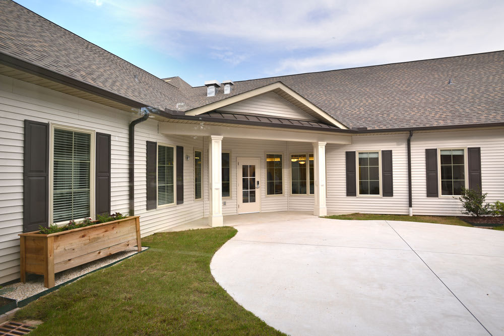 A view of a modern residential house with a front porch and driveway.