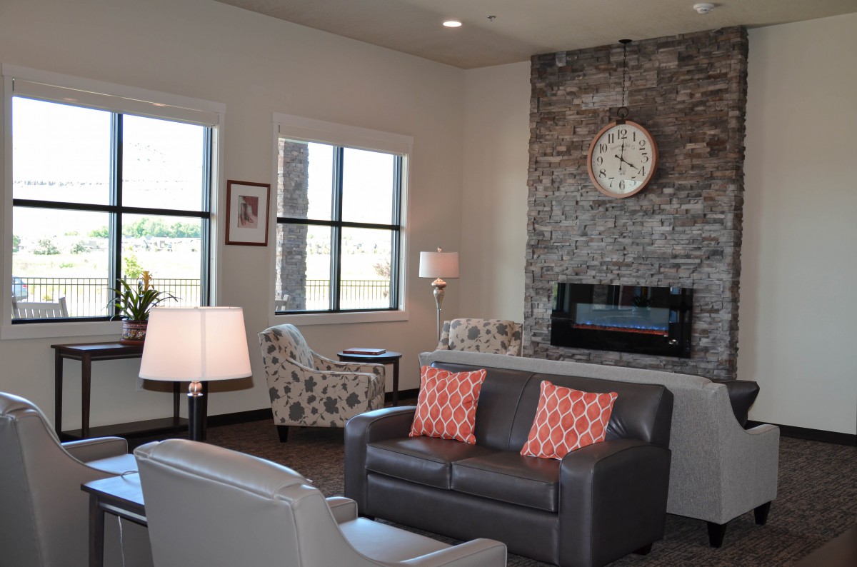 A modern living room featuring a stone fireplace, comfortable seating, and stylish decor.