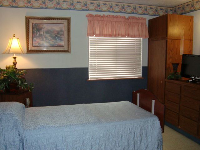 A bedroom with a single bed, window blinds, and a wardrobe.